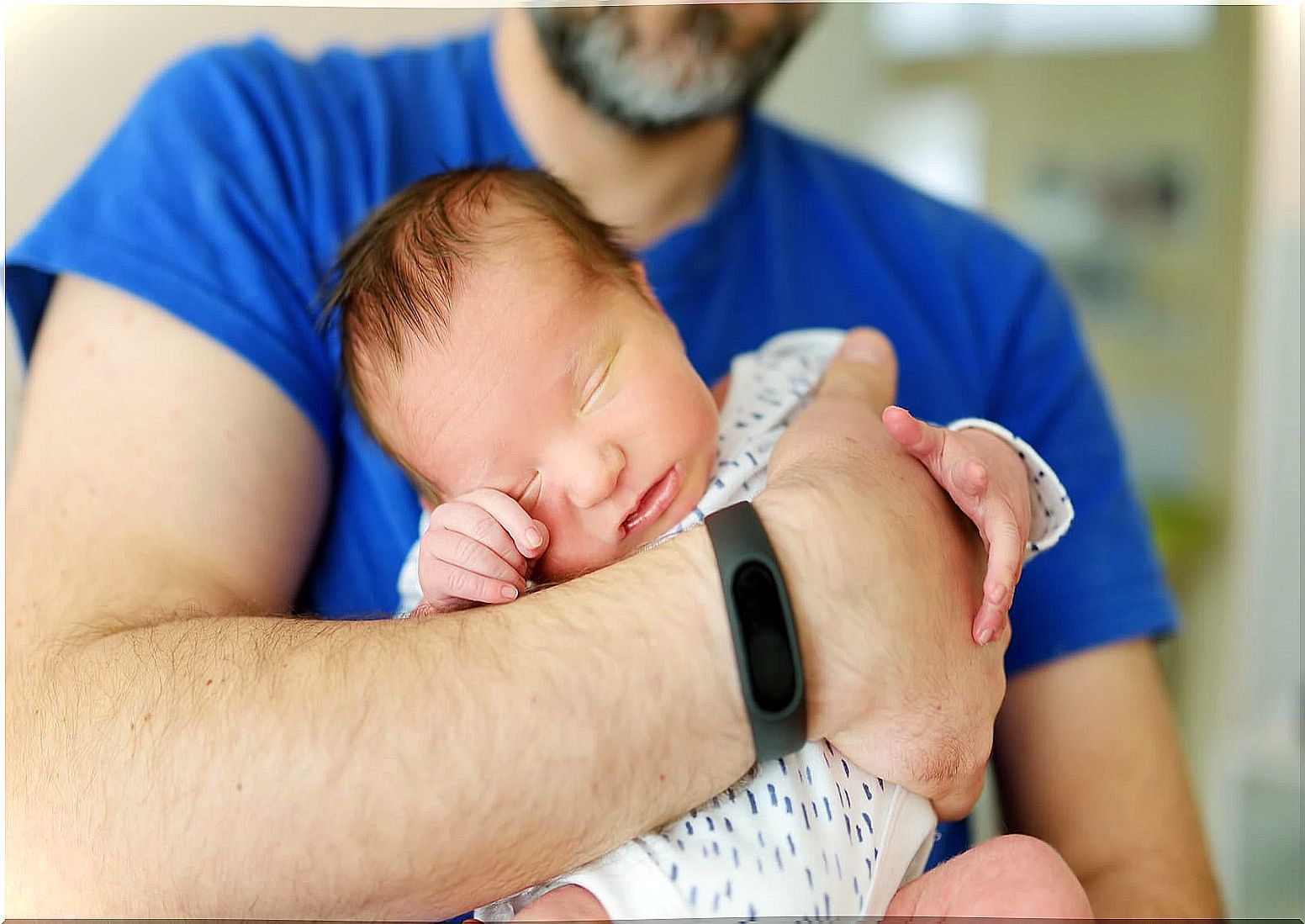 Dad with his newborn baby in his arms.