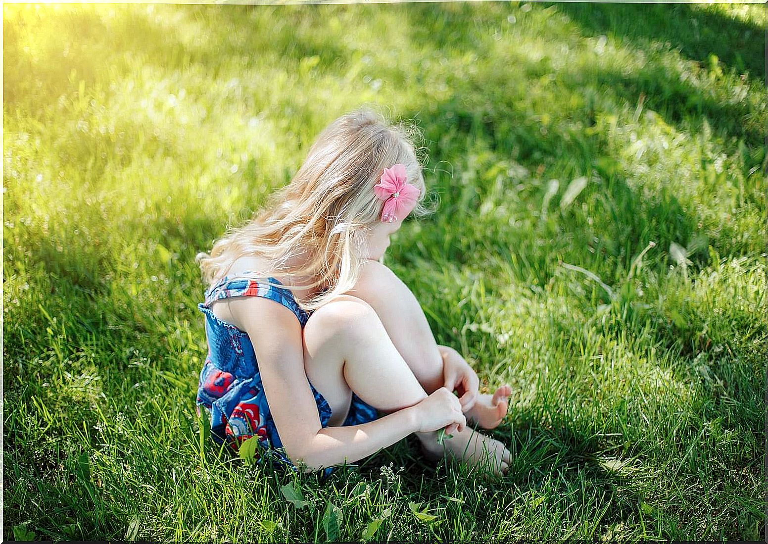 Insecure girl sitting on the grass.