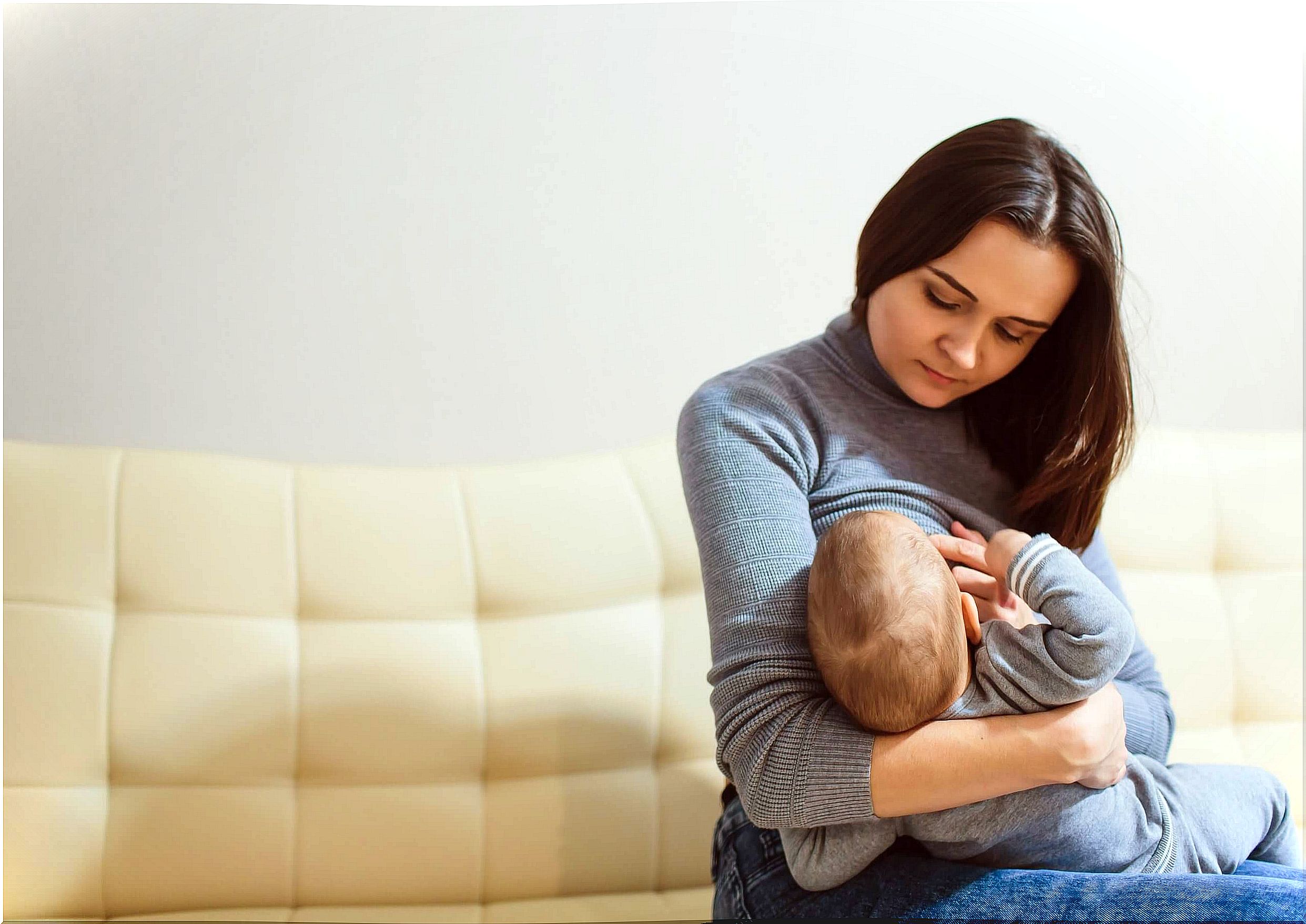 Mother thinking about breastfeeding phrases while breastfeeding her child.