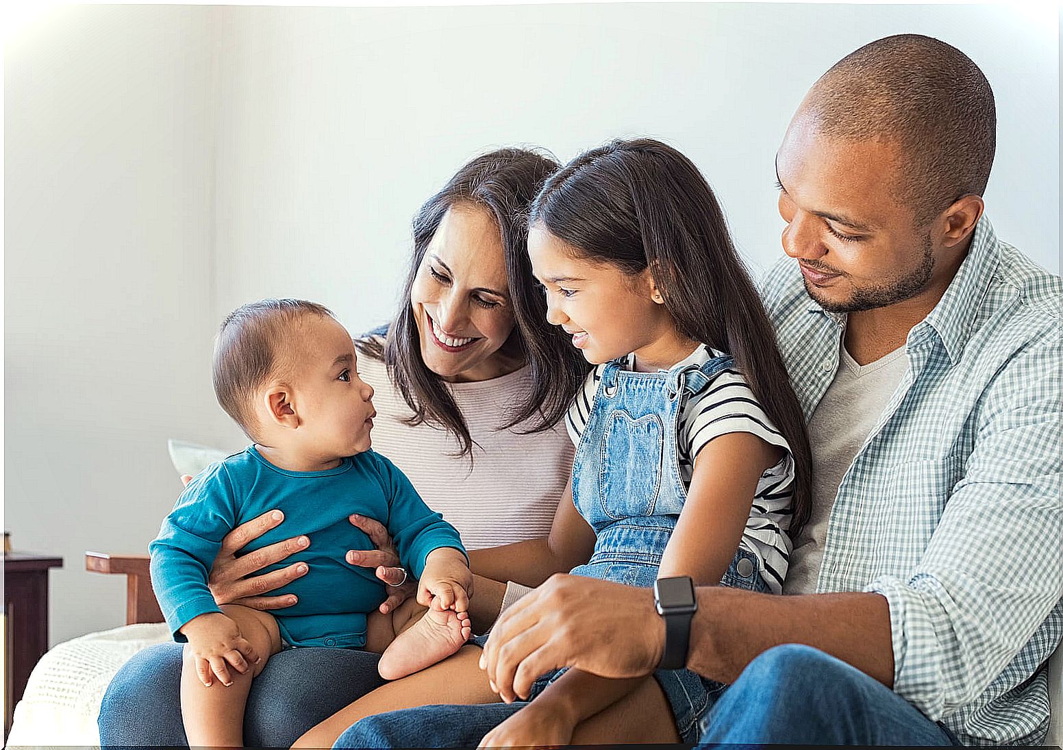 Parents hugging their two children to improve relationships in the family environment.