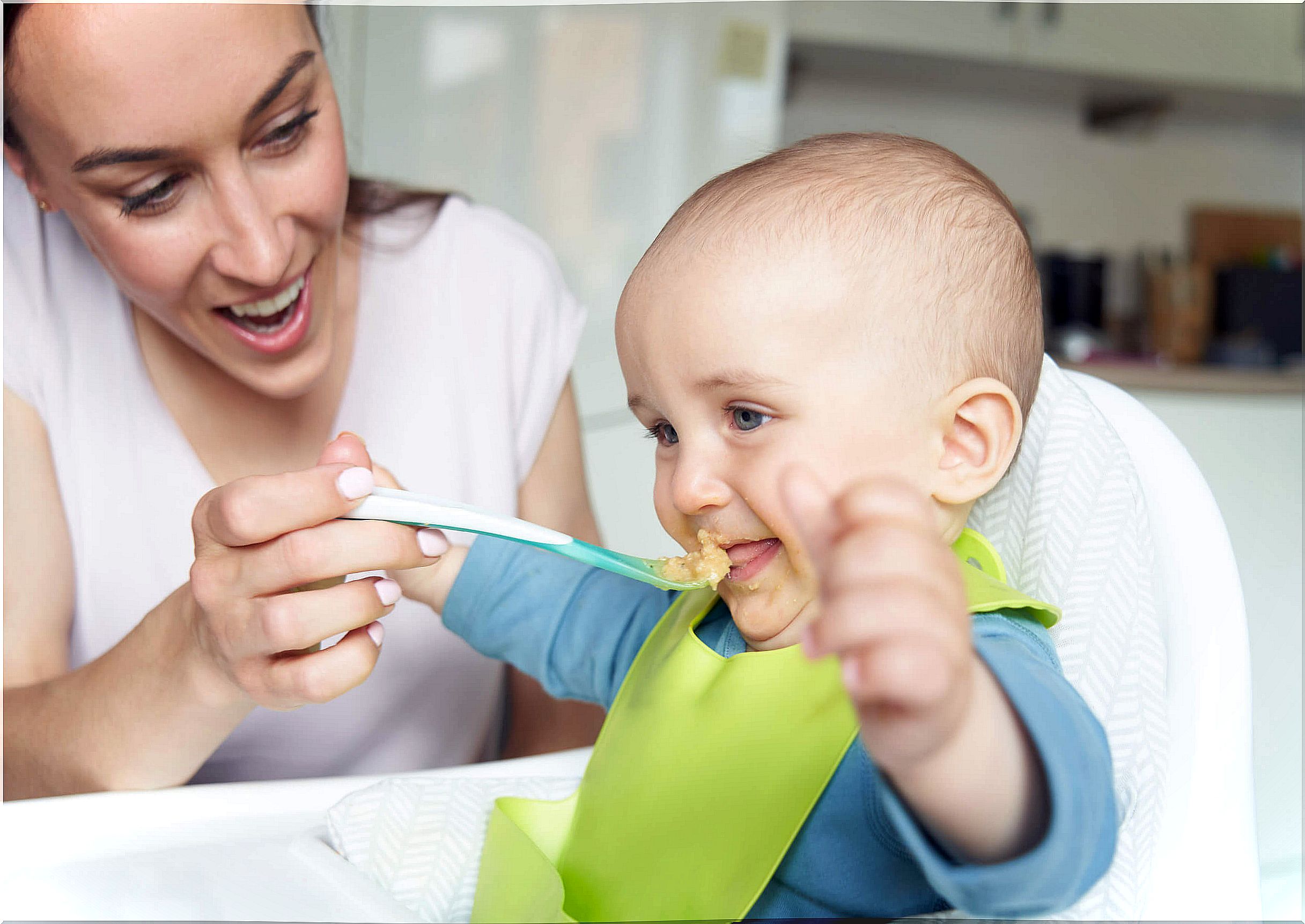 Mother giving complementary feeding to her son.