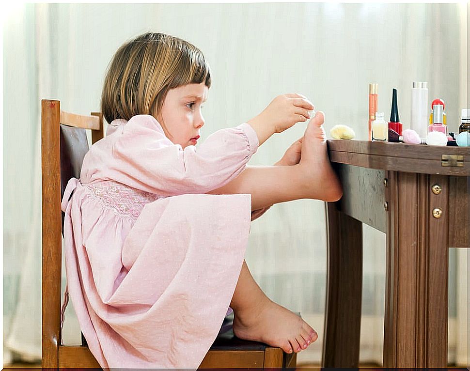 Girl painting her nails due to social learning.