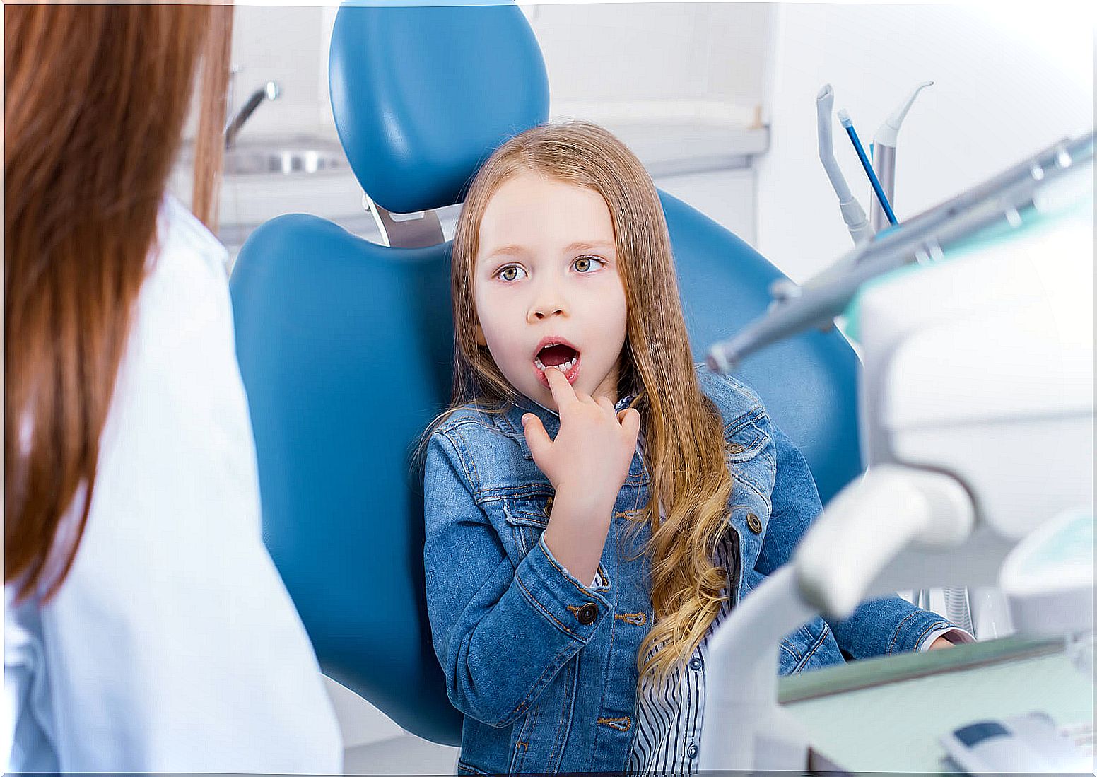 Little girl at the dentist because she suffers from tooth sensitivity.