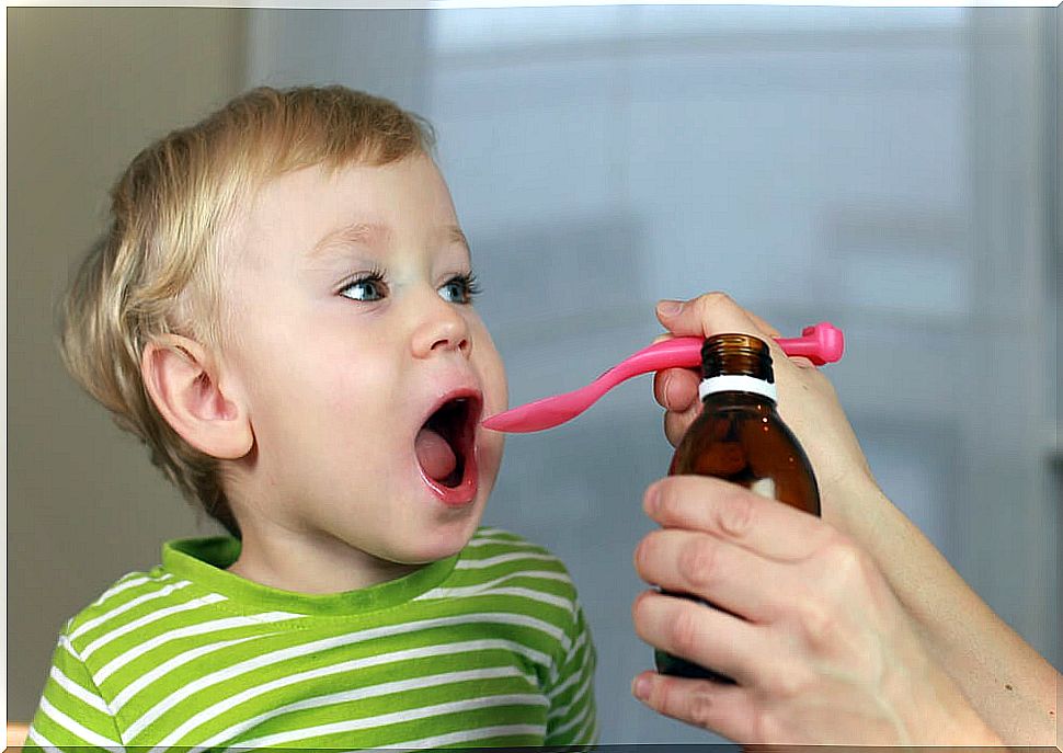 Mother giving ibuprofen syrup to her son.