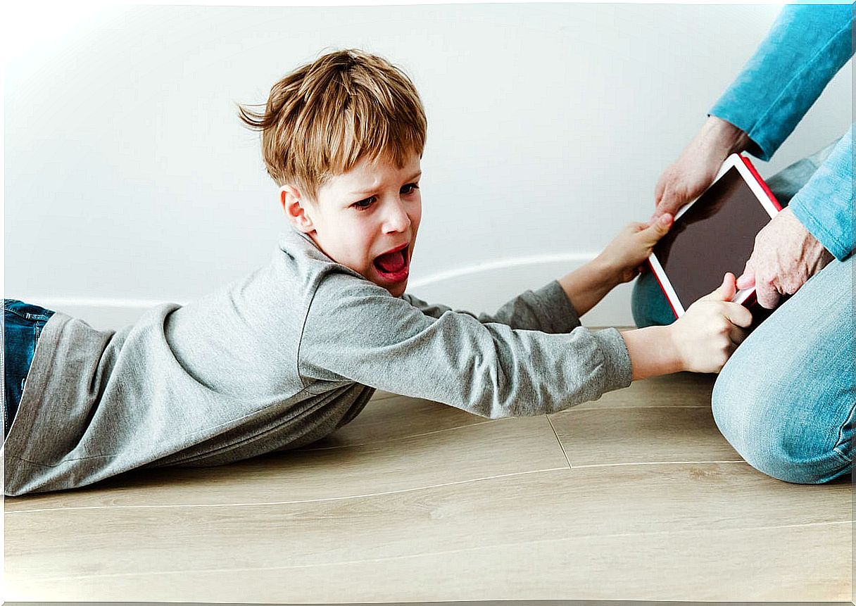 Boy screaming because his mother took his tablet from him because he suffers from digital stress.