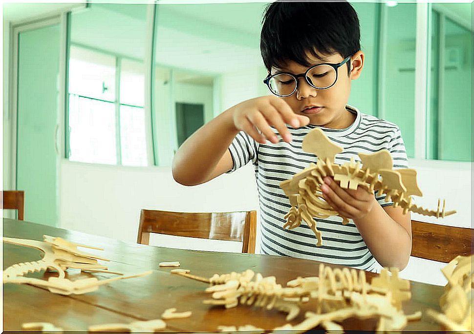 Child in class making a model of a dinosaur and taking into account the educational importance of individual differences.