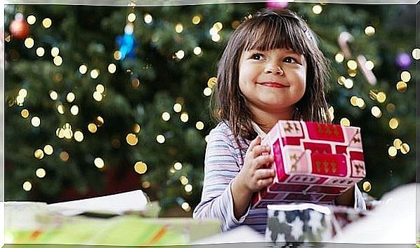 Little girl with a gift under the christmas tree