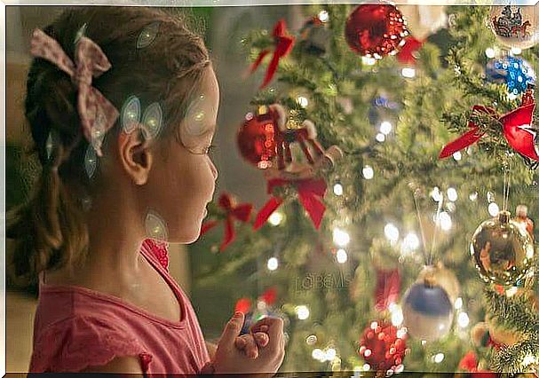 Little girl looking at an illuminated Christmas tree