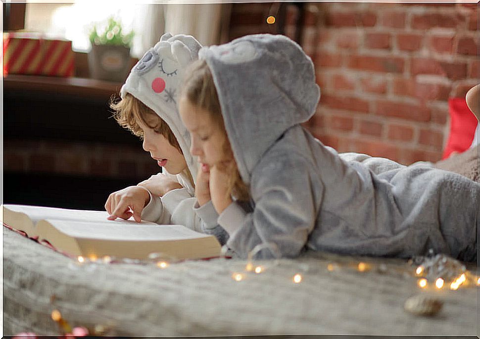 Children reading history riddles with their pajamas on.