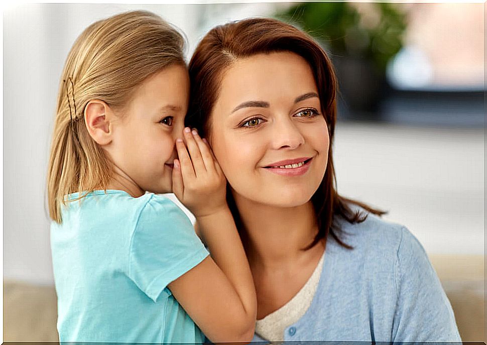 Mother listening to what her daughter whispers in her ear about an experience with toxic people.