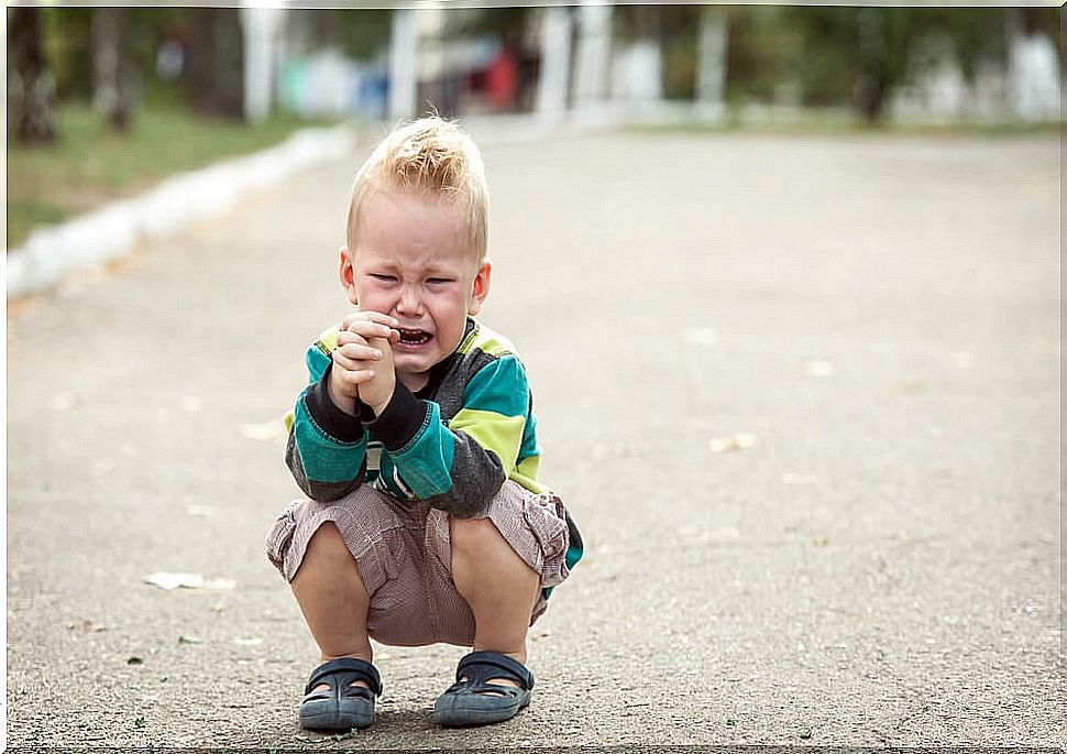 Sensitive child crying in the street.