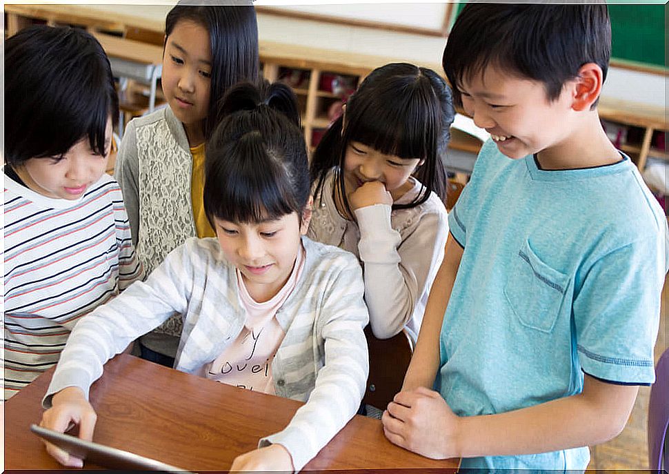 Children in class with a tablet studying how osmosis learning works.