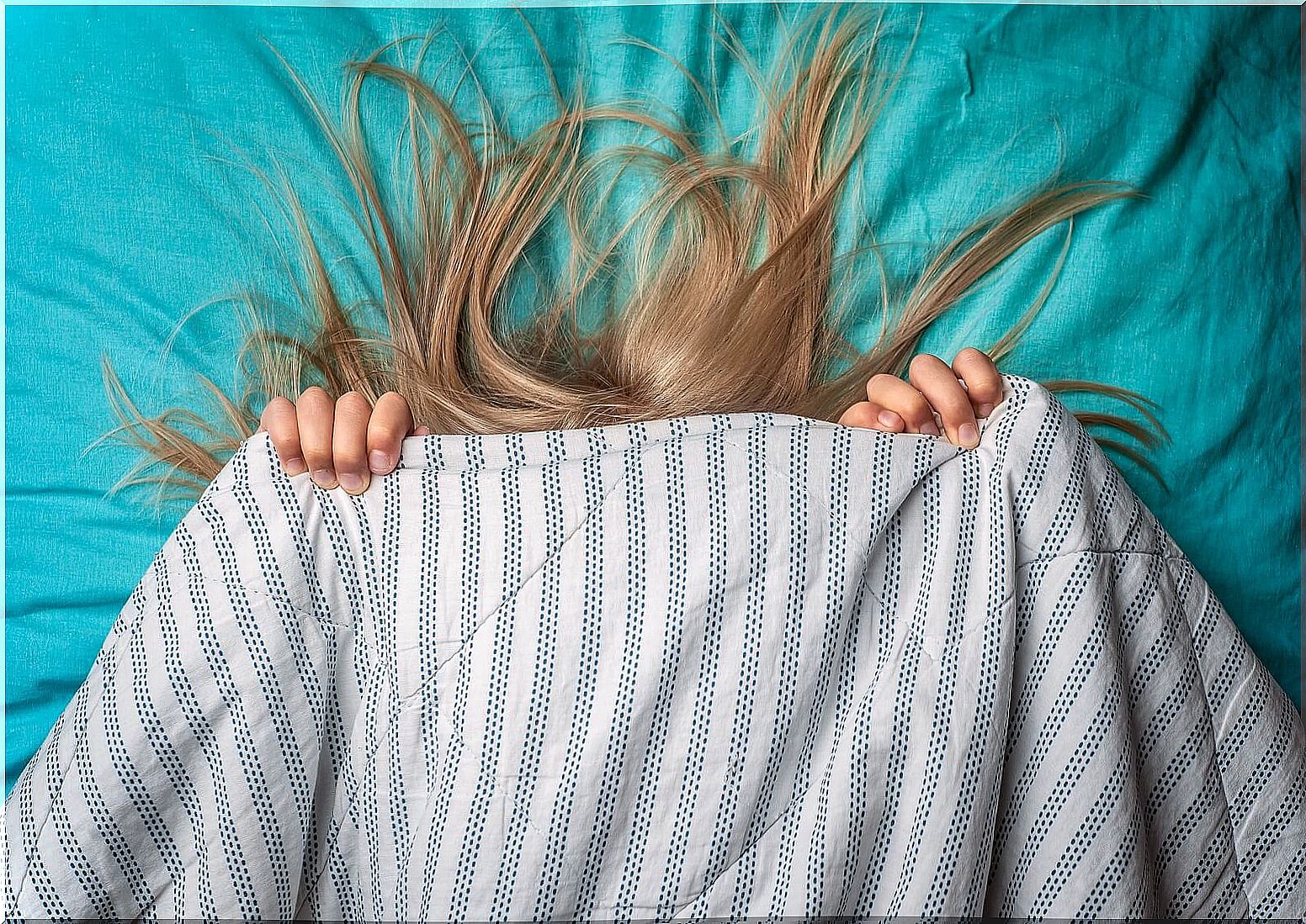 Girl covered with the sheet because she suffers nightmares.