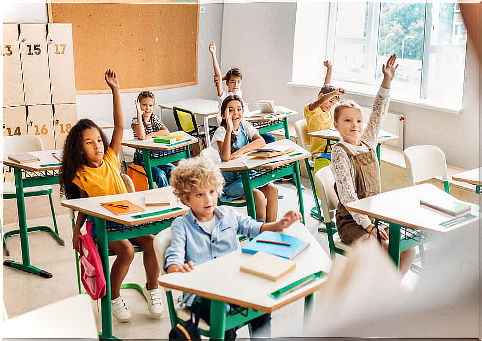 Students raising their hands with very good participation in the school.