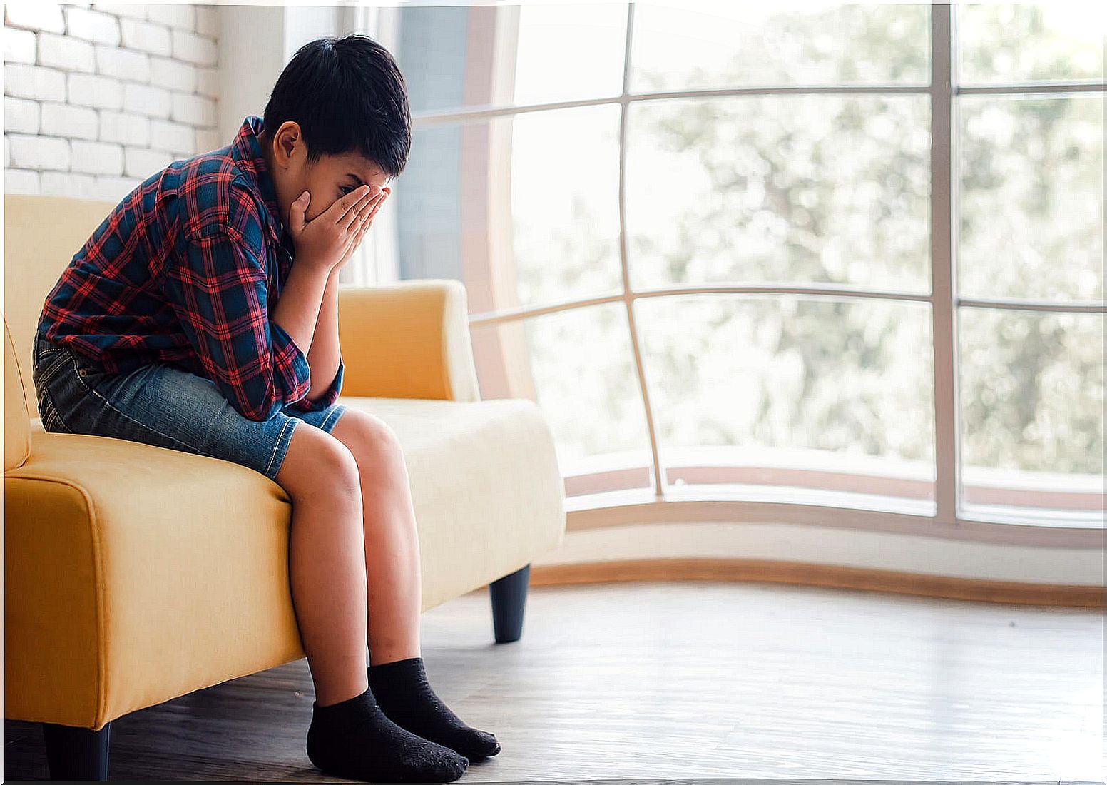 Boy crying because he suffers from childhood depression.