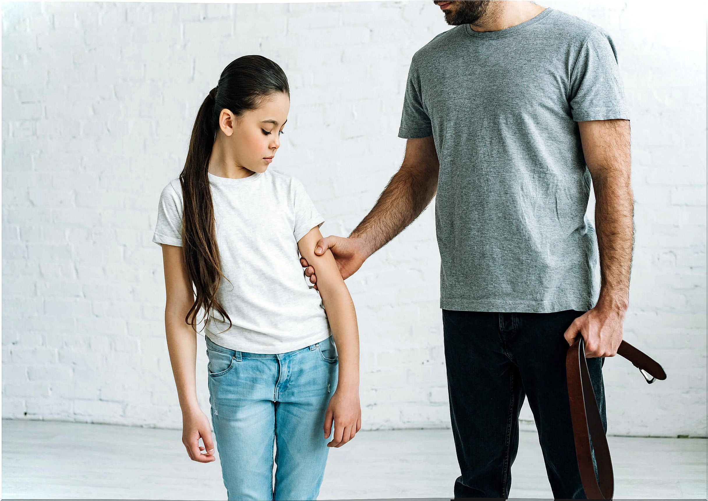 Father applying physical punishment to his daughter.