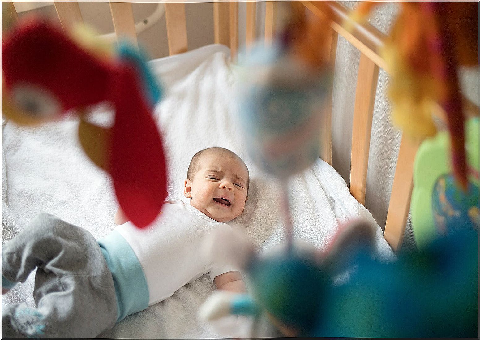 Crying baby in his crib.