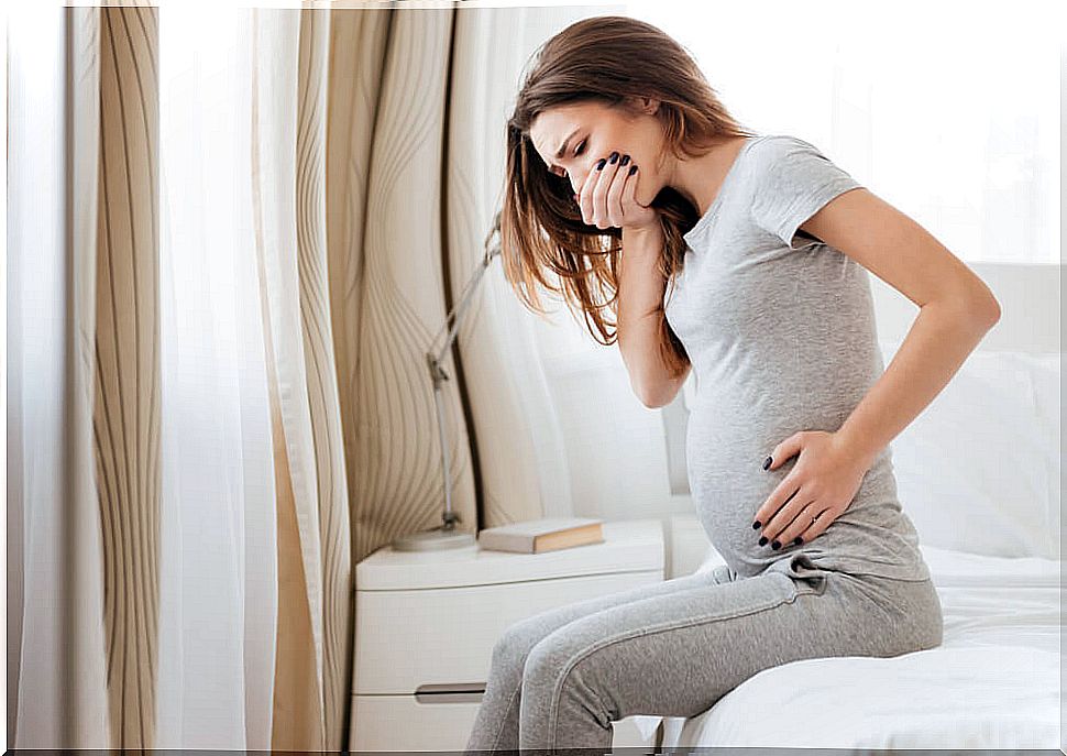 Pregnant woman sitting in bed with nausea and vomiting before starting treatment.