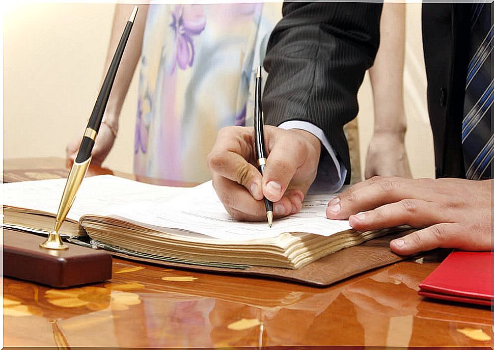 Parents signing in the Civil Registry to register their child and request the Family Book.