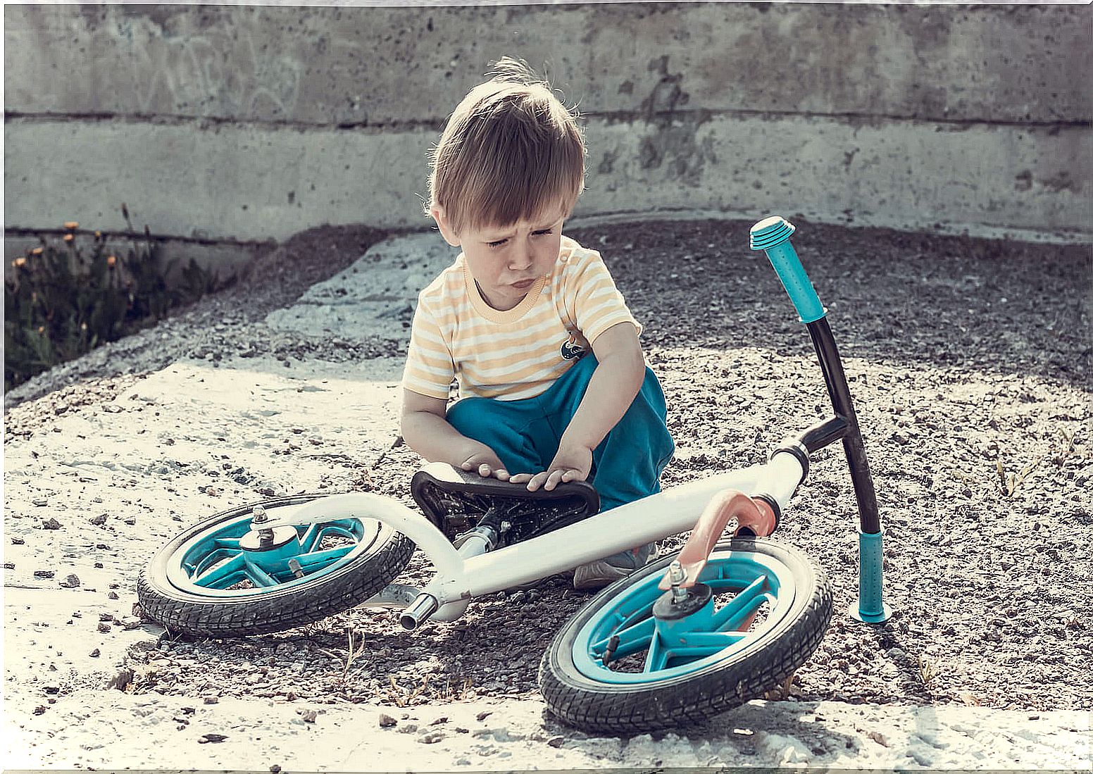 2-year-old boy with the bicycle lying on the ground.