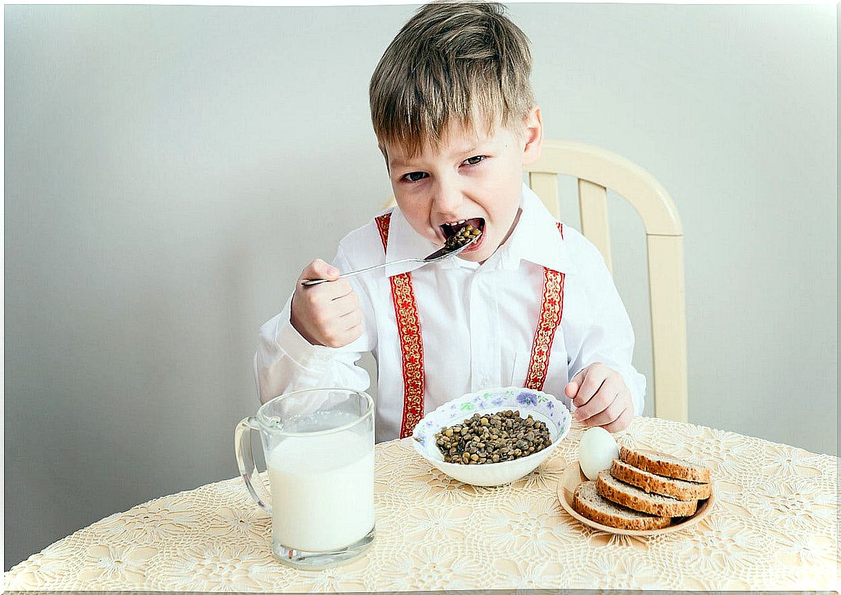 Child eating lentils because legumes are very important.